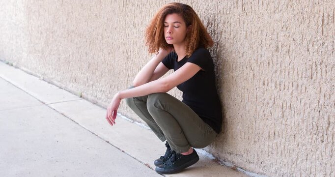 Depressed and frustrated young woman against wall 4k