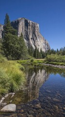 A tranquil river reflecting a majestic granite monolith against a vibrant blue sky, showcasing a serene natural landscape.