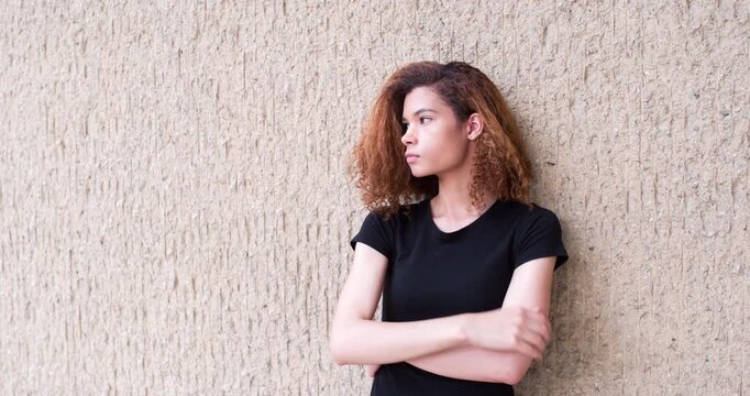 Sad and depressed young woman standing against wall 4k