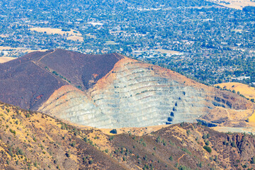 View from Mount Tamalpais East Peak in Marin County, California, overlooking a terraced quarry and the Bay Area cityscape, contrasting natural hills with industrial landscape