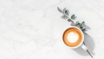 Elegant coffee with latte art presented with a sprig of greenery against a clean marble textured surface, suggesting simplicity and morning refreshment