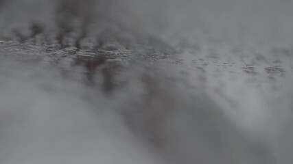 Close-up view of heavy condensation and water droplets running down a steamy glass surface. Abstract, humid background texture perfect for overlays and environmental concepts.