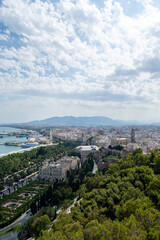 Panoramic view of a coastal city with greenery and mountains