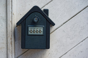 Metal key safe with keypad on white wooden surface outside