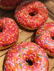 Delicious chocolate doughnuts with sprinkle topping on a tray