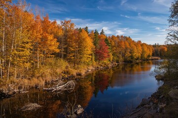 Obraz premium Colorful autumn forest and lake panorama from a scenic trail viewpoint.