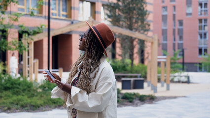 A woman uses a city map and geolocation on her smartphone to navigate the area while traveling.