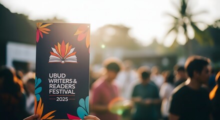 Promotional sign for a vibrant literary festival, held outdoors with a large crowd enjoying the cultural community event at sunset