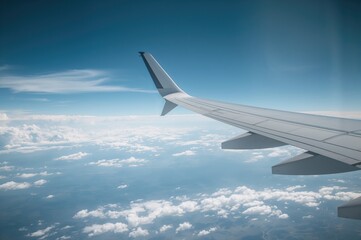 Obraz premium Aircraft wing soaring through the clouds