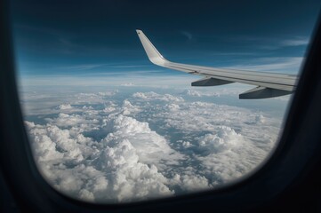 Obraz premium Sky-high perspective of an elegant airplane wing soaring above the clouds, symbolizing exploration and liberty from a window seat viewpoint.
