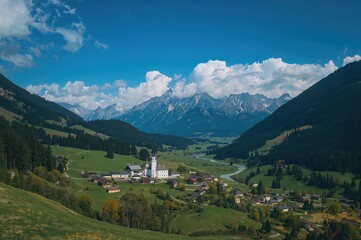Bird's-eye View of a Mountain Hamlet Nestled in the Valley with Tall Peaks in the Distance