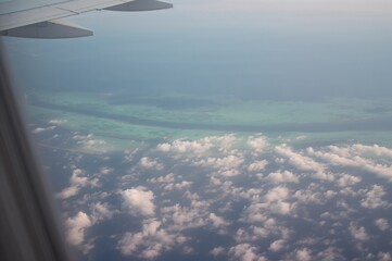 Fototapeta premium View from an airplane window showing a tropical island paradise from above, perfect for a vacation
