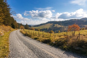 Fototapeta premium Sunny autumn morning on a gravel path in mountainous terrain with blue sky and clouds