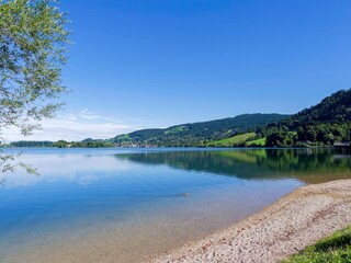  Beautiful Schliersee lake in the Bavarian Alps. Small beach along the southeast shore with views of the town of Schliersee and the slopes of the Schliesberg

