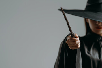 Magic wand in the hand of woman dressed in witch clothes.