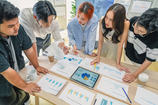 Topview business meeting shows financial startup documents, charts and strategic planning papers while diverse team brainstorms innovative ideas for scalable growth and market expansion goals