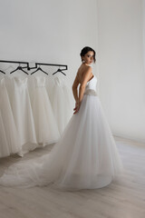 Beautiful woman wearing strapless wedding dress with corset back indoors