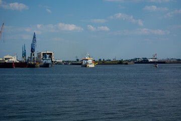 Fototapeta premium Harbor view with ships and cranes under blue sky