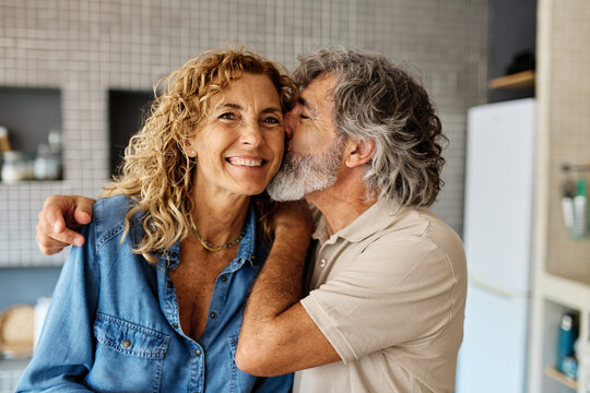 Portrait of happy senior mid aged mature couple prepering meal with fresh vegatebles in kitchen at hpme - Powered by Adobe
