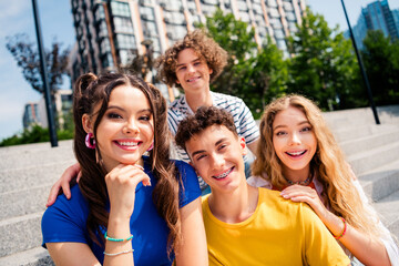 Happy young friends enjoying a sunny day outdoors together with a vibrant modern cityscape in the background