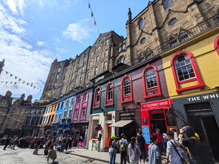 Naklejka premium Crowds of tourists on the colorful curved Victoria Street in Edinburgh's historic Old Town