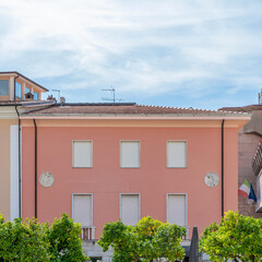 Orange trees and colorful buildings in the central square of Massa, Italy