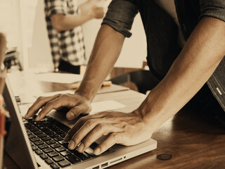 Closeup of business man hand typing on laptop computer on table at office.