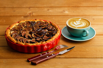 Homemade pie with pears and figs on wooden table.