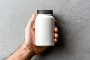 hand holding supplement bottle with blank label against simple backdrop