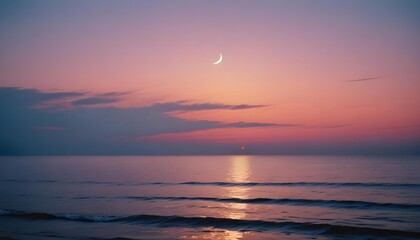 Obraz premium Serene coastal sunset with a crescent moon over the ocean.