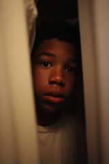  11 year old black boy hiding scared in a closet.