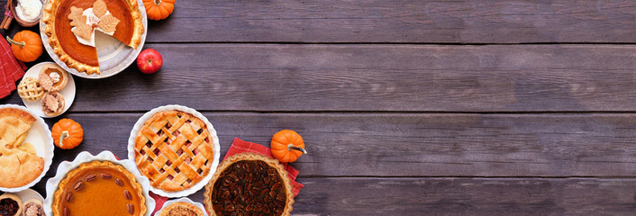 Fototapeta na wymiar Homemade autumn pie corner border. Top down view on a dark wood banner background with copy space. Variety of apple, pumpkin and pecan pies.