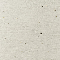 Plain beige textured wall with small scattered specks and subtle shadows for background use