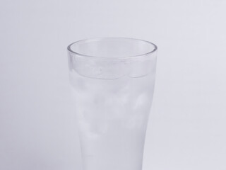Close-up tall glass of ice-cold water with condensation and ice cubes on white background. Perfect for hydration, freshness, health, purity, and summer themes.
