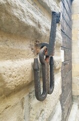 An antique iron hitching post for horses on the wall of a house in Siena, Italy