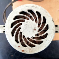 Old electric fan on a black background. Close-up. Selective focus.