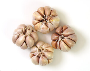 Top view of four whole garlic bulbs placed on a white background