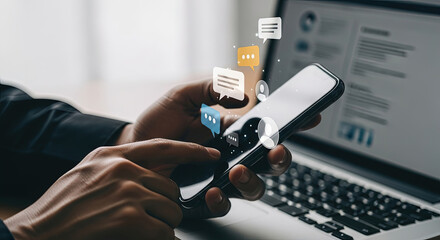 Modern Business Communication: Man Using Smartphone for Messaging and Social Media with Laptop Background, Illustrating Connectivity and Technology