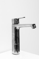 A faucet on a white background, a plumbing fixture that controls the flow of hot and cold water.