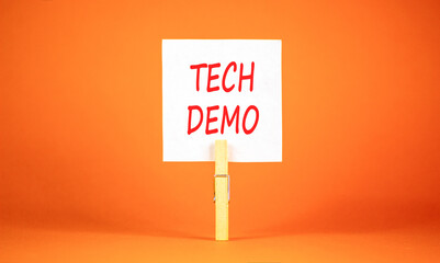 Tech demo symbol. Concept word Tech demo on beautiful white paper. Beautiful wooden clothespin. Beautiful orange background. Business tech demo concept. Copy space.