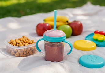 Baby toddler smoothie with fruits outdoors