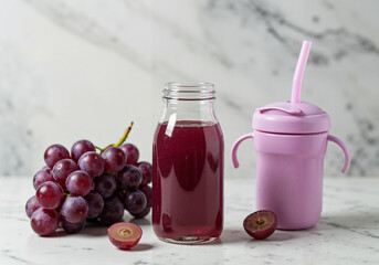 Baby grape juice in glass bottle with fresh grapes on marble background