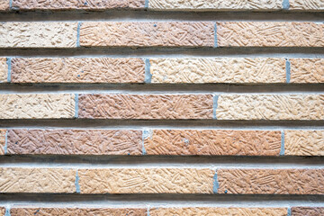Stone wall with much brown bricks of the modern building.