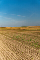 a landscape depicting empty fields after the harvest season in early autumn