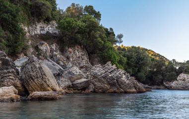 Calm sea at shore with large rocks, typical scenery at one of many bays in Liapades, Greece