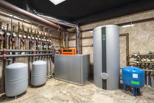 A well-organized boiler room features modern heating equipment, including storage tanks and piping systems. This setup ensures energy efficiency and reliable heating for the building