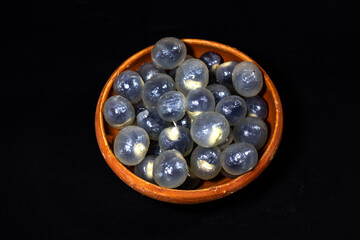 Bunch of peeled longan fruits, kept in a earthen bowl. Ideal for food, nutrition, wellness, healthy lifestyle, raw fruit, and culinary themes