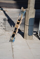 wooden pallet leaning against a street light pole