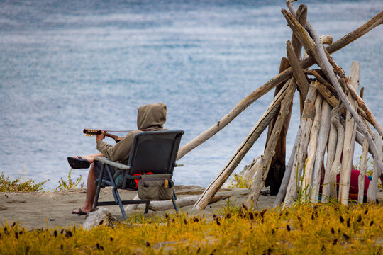 Man playing guitar on beach - Powered by Adobe