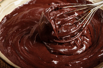 a bowl of chocolate dough, a whisk for whipping, baking, structure and consistency, homemade, top view, no people,